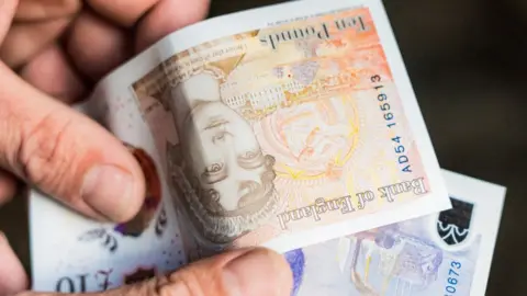 Getty Images Hand with £10 notes