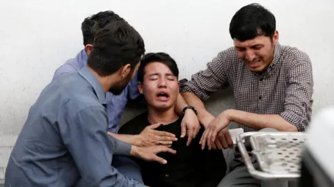 Reuters People comfort a distressed man at the scene