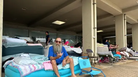 Tom Leonard sits on his air mattress