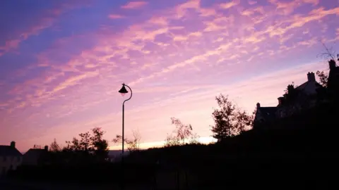 Getty Images Silhouette of a residential street at dawn with Stratocumulus cloud formation.