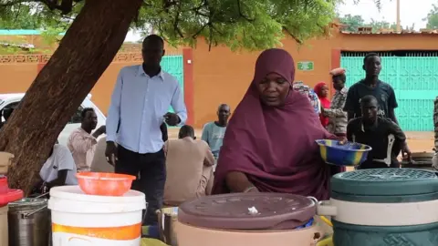 BBC Zara Kada serving food at her stall.