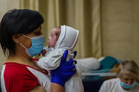 Getty Images A nurse with a baby in Kyiv's underground nursery