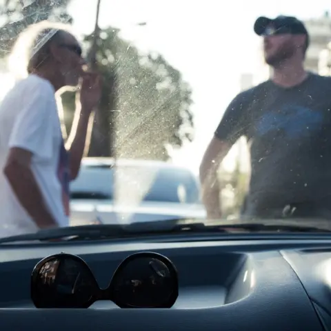 Nicky Willcock  Two men pictured through the windscreen of a car