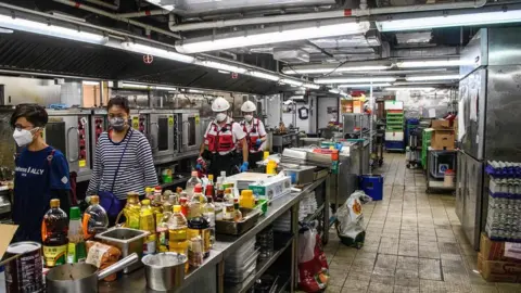 AFP A team walk though a canteen kitchen at PolyU