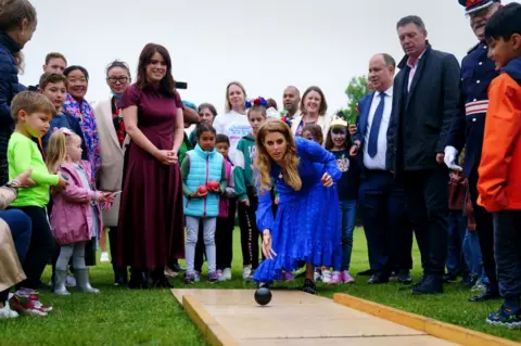 PA Media Princess Beatrice (centre) and Princess Eugenie (left) play on the bowling alley during the Big Jubilee Lunch organised by Westminster Council