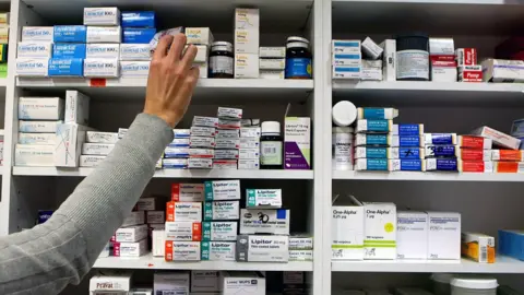 Julien Behal Pharmacist stocking shelf