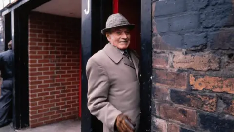 Bill Stephenson A man enters the stadium through a turnstile