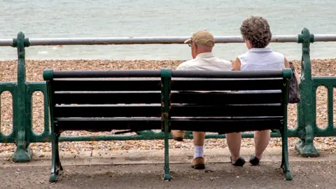 Couple sitting on a bench on the beachfront