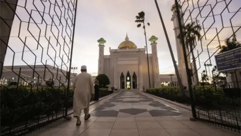 European Photopress Agency A Muslim man walks inside the Sultan Omar Ali Saifuddien mosque to perform the sunset prayer in Bandar Seri Begawan, Brunei, 1 April 2019