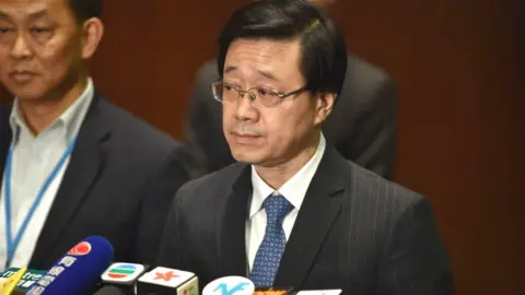 Getty Images Secretary for Security John Lee speaks to journalists at the end of the first session at the Legislative Council in Hong Kong on June 19, 2019, after massive protests brought nearly two million people into the streets at the weekend.