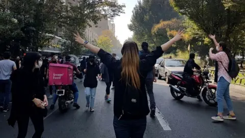 EPA A woman without her headscarf gestures during a protest in Tehran, Iran (1 October 2022)