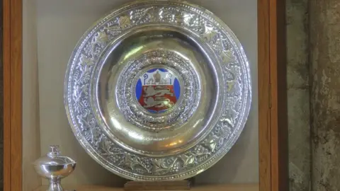 Malmesbury Abbey Decorative large silver plate and cup, with the plate having an enamel coat of arms in the middle