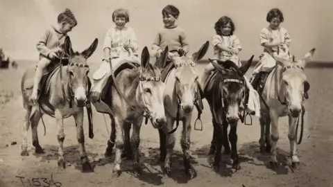 National Portrait Gallery/Ancestry A typical seaside scene from the 1920s of children riding donkeys. My mother is on "Bobby" and her sister is sitting on "Lily". My mother was always happy around animals, her sister not so, which I think the photo shows.