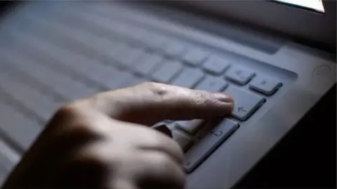 PA Hand hovering over keyboard