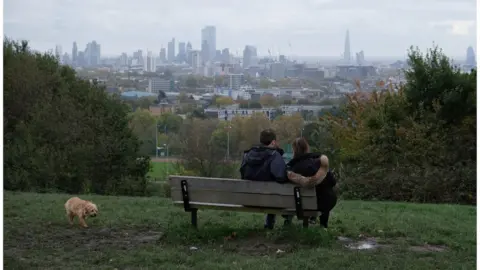 Kaveh Kazemi / Getty Images A couple take in the view at London's Parliament Hill in November 2019