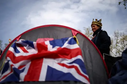 HENRY NICHOLLS/REUTERS A woman camps on the Mall outside Buckingham Palace ahead of the Coronation