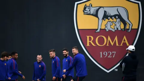 AFP AS Roma players train in front of an uncensored club badge