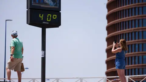 Getty Images A woman takes pictures of a thermometer reading 40 degrees Celsius on June 21, 2026 in Seville, Spain. Western Europe i