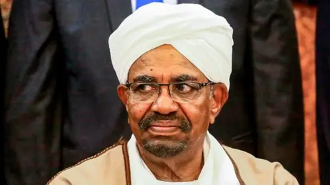 AFP Sudan's President Omar al-Bashir poses for a group photo with members of his new 20-member cabinet as they take oath at the presidential palace