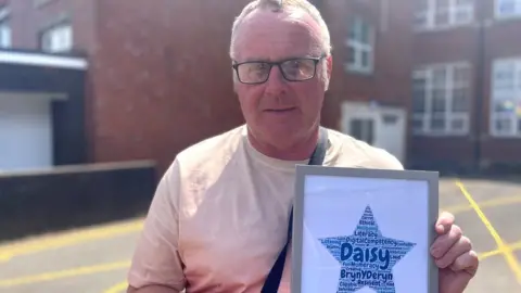 Richard showing his daughter's year 11 award