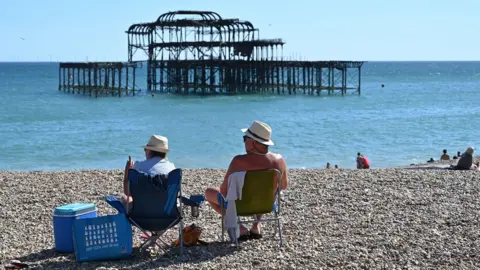 Getty Images Two people relaxing on a beach in Brighton