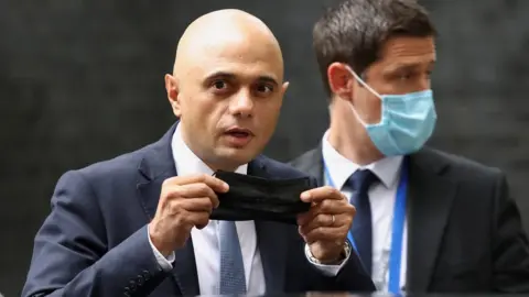 Reuters Sajid Javid holding a face mask