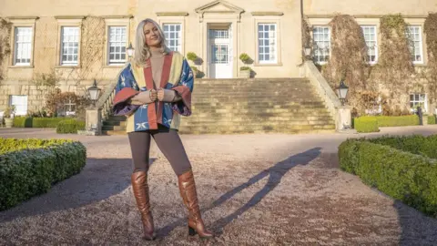 PA Media model stands outside historic building wearing blue, yellow and red kimono