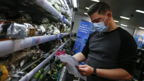 Getty Images Man wearing face mask in a shop in London
