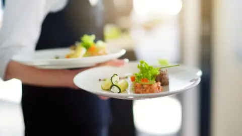 Getty Images Waitress holding two plates