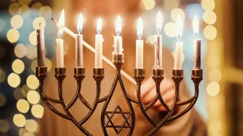 Getty Images A child lighting the Menorah candles