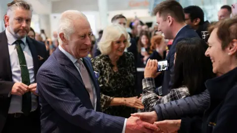 PA Media The King, who is patron of Cancer Research UK, and the Queen, meet staff at University College Hospital Macmillan Cancer Centre