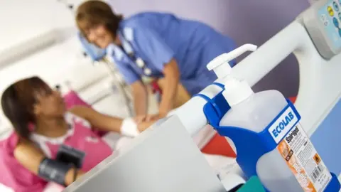 Science Photo Library Hospital bed - with hand-washing gel