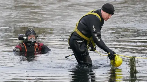 PA Media Police divers search the lake in Babbs Mill Park in Kingshurst, Solihull