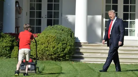 Getty Images President Trump with boy mowing White House lawn