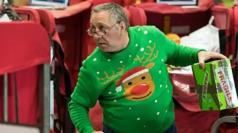 Getty Images Royal Mail worker in a Christmas jumper