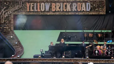 Joe Giddens/PA Elton John singing and playing the piano at Norwich gig