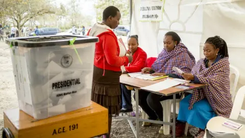 Getty Images A Kenyan resident gets ready cast their ballot