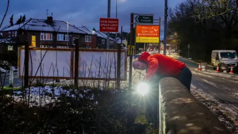 Magnum Photos A council worker in Didsbury, Manchester, checks a bridge over the River Mersey for damage after heavy rainfall.