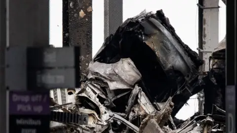 TOLGA AKMEN/EPA-EFE/REX/Shutterstock  Burnt cars at London Luton Airport