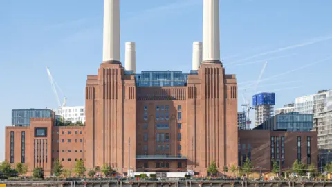 Battersea Power Station - a red brick building with four tall white chimneys