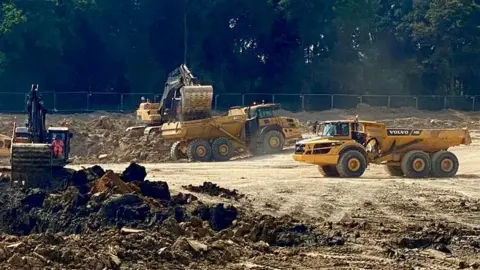 Diggers are churning up earth at a building site