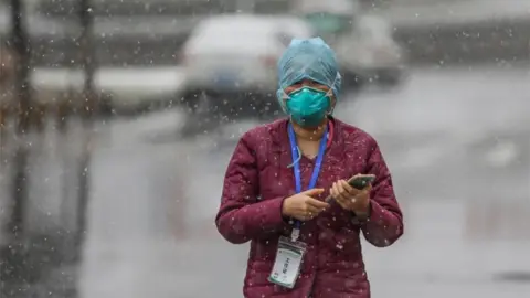 EPA A government worker in Wuhan at the epicentre of the coronavirus outbreak in China, 16 February 2020