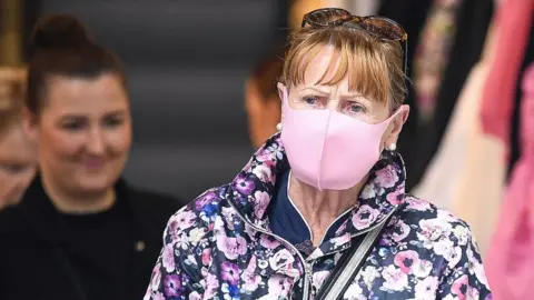 Getty Images Shopper wearing face covering