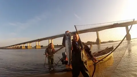 Visual Impact Productions Fisherman with a salmon beneath Severn bridge