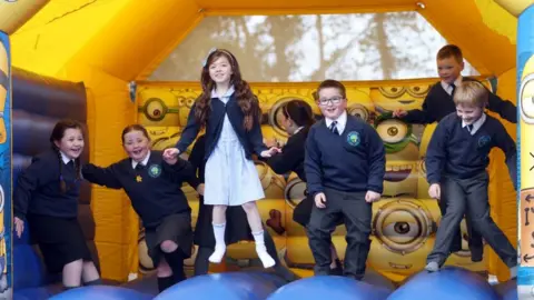 Pacemaker Pupils of Braniel Primary School in Belfast jumping on a bouncy castle