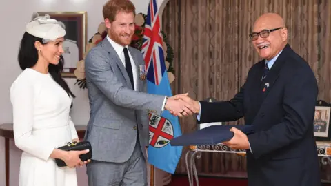 Getty Images Meghan, Duchess of Sussex and Prince Harry, Duke of Sussex present a gift to the President of Fiji Jioji Konrote