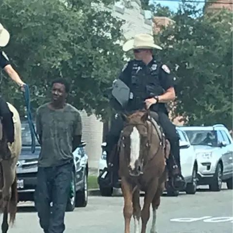 Anonymous Two officers on horseback leading suspect on foot