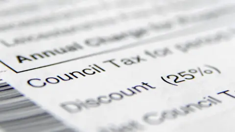 PA Media A council tax document lies on a surface. Words on the document have been blurred apart from the words 'council tax' and information on a discount.