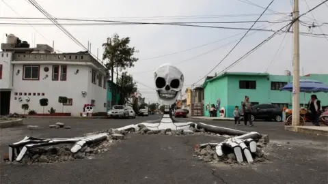 EPA A cardboard skeleton emerges from a street in Mexico City