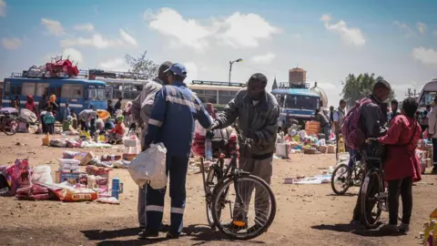 Milena Belloni A bus station with old buses, markets traders and some people with bicycles in Asmara, Eritrea